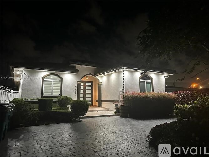 A house with a lit up entrance at night.