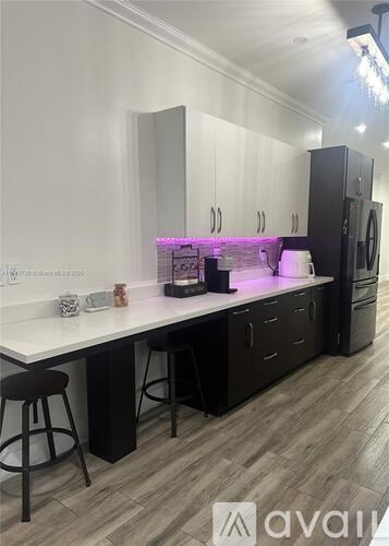 A modern kitchen with a white countertop and black cabinets.