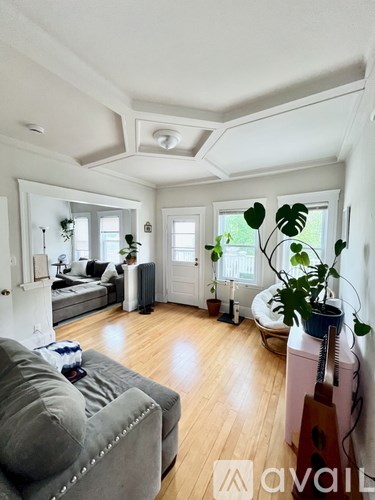 A living room with a grey couch and a wooden floor.