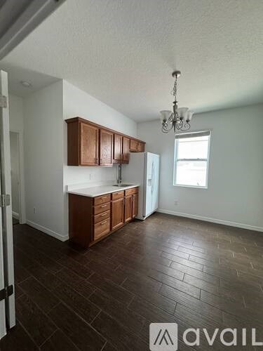A kitchen with brown cabinets and a chandelier.