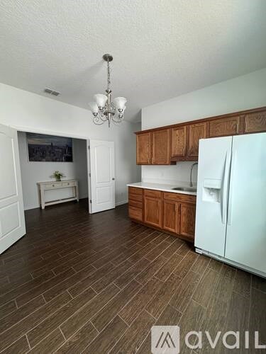 A kitchen with a white fridge and wooden cabinets.