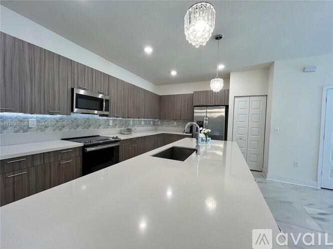 A modern kitchen with a long white countertop and wooden cabinets.
