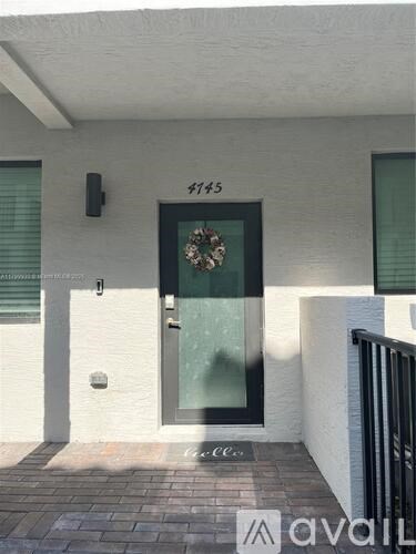 A white house with a glass door and a wreath on it.
