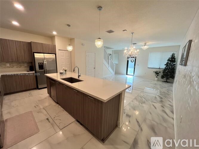 A spacious kitchen with a marble floor and a central island.