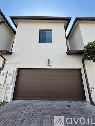 A two-story house with a garage and a window on the second floor.