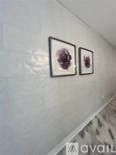 Two framed artworks hang on a wall above a staircase.