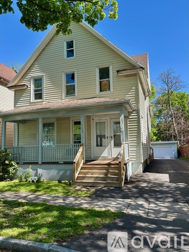 A two-story house with a front porch and a white door.