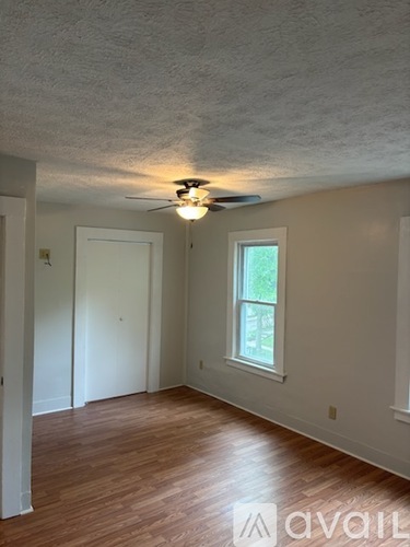 A room with a ceiling fan and a window.