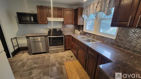 A kitchen with brown cabinets and a patterned backsplash.