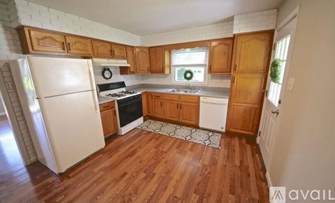 A kitchen with wooden cabinets and a white fridge.
