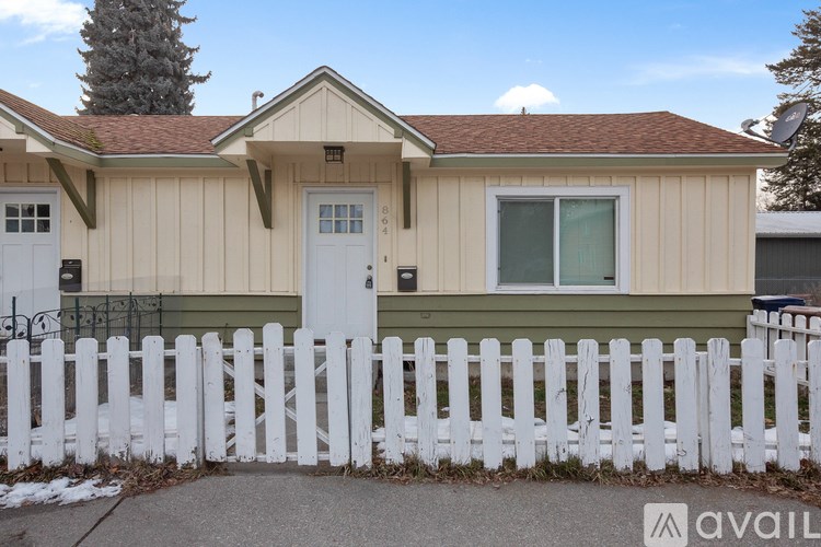 A house with a white picket fence in front.