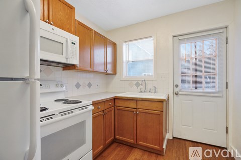A kitchen with wooden cabinets and white appliances.