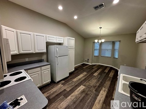 A kitchen with white cabinets and a refrigerator.
