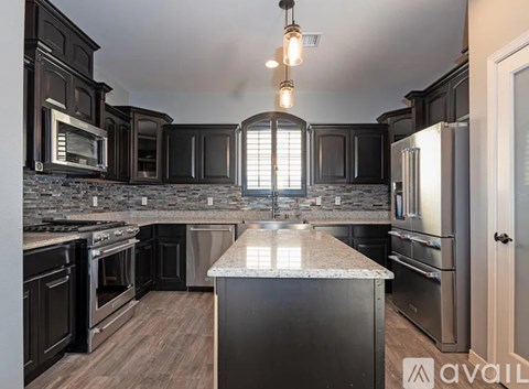 A kitchen with dark wood cabinets and stainless steel appliances.