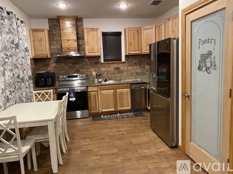 A kitchen with a table and chairs and a refrigerator.