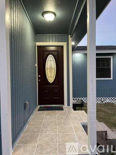 A dark brown door with a glass window is set in a blue wall.
