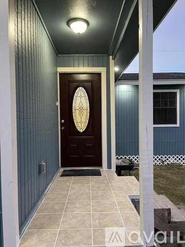 A dark brown door with a glass window is set in a blue wall.