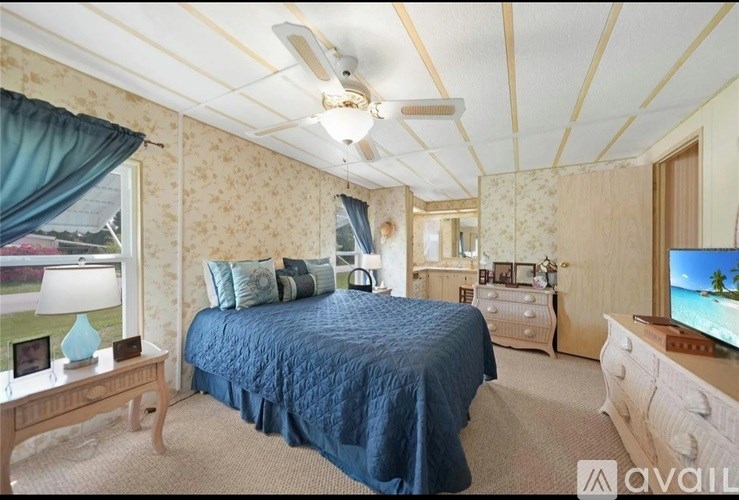 A bedroom with a bed, dresser, and television.