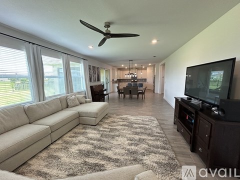 A living room with a large sectional sofa and a flat screen TV.