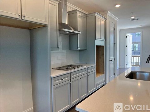 A kitchen with white cabinets and a stainless steel sink.