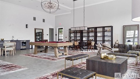 A modern living room with a large wooden table and a variety of seating options.