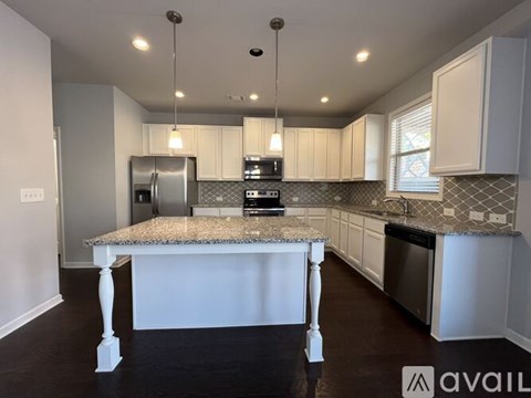 A kitchen with a granite countertop and white cabinets.