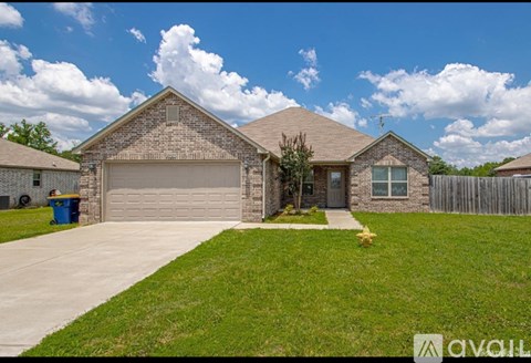 A house with a garage and a driveway in front of it.