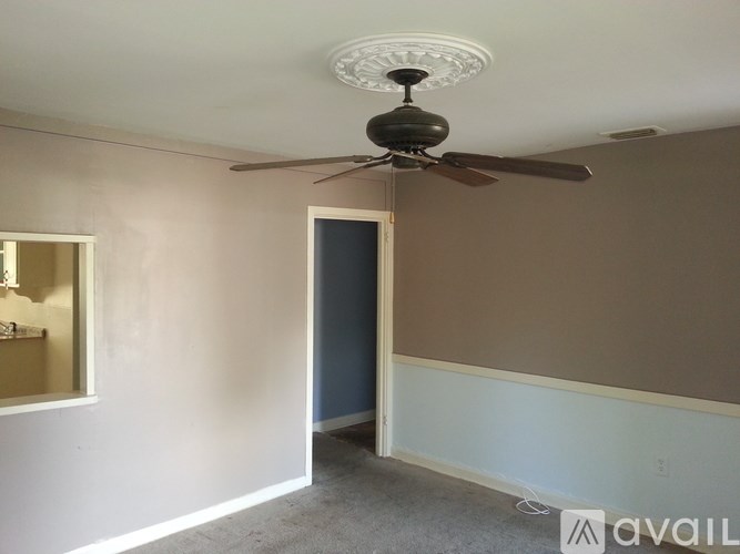 A room with a ceiling fan and a door.