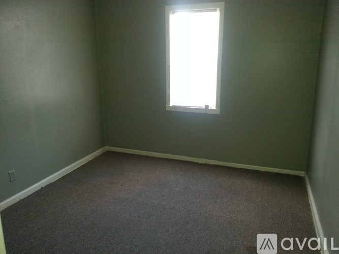A room with a window and carpeted floor.