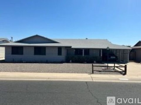 A house with a grey roof and a white wall is available for rent.