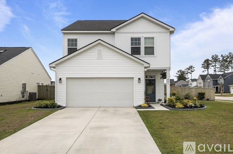 A white house with a grey roof and a garage door.