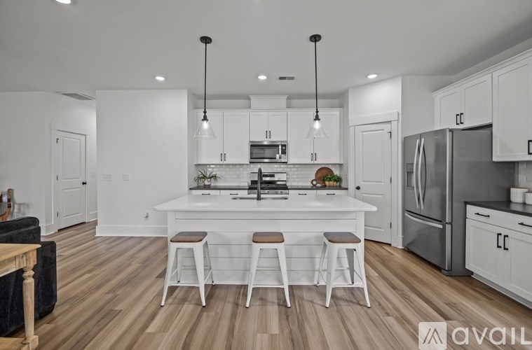 A kitchen with white cabinets and a wooden floor.