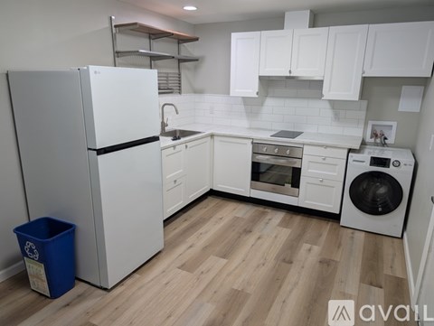 A kitchen with white appliances and wooden floors.