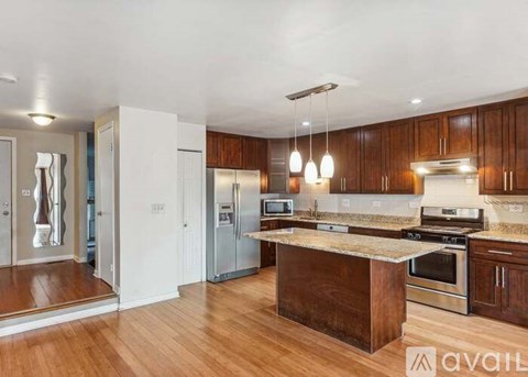 A kitchen with wooden cabinets and a central island.