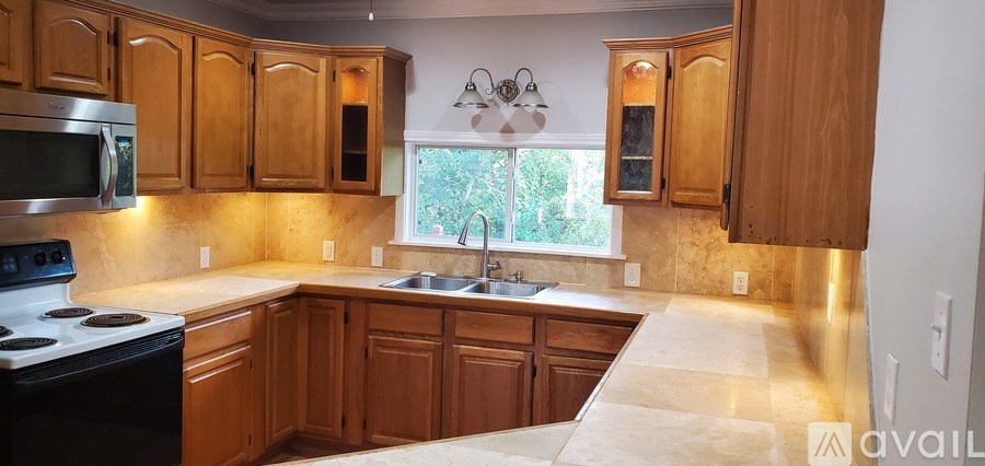 A kitchen with wooden cabinets and a stove top oven.