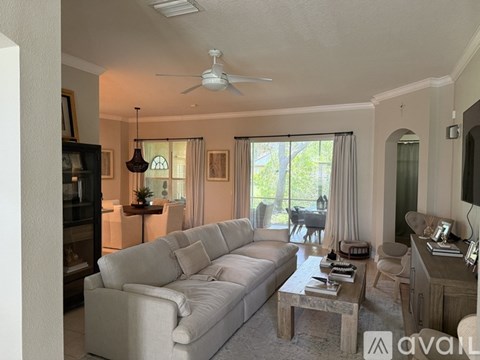 A living room with a white couch and a ceiling fan.