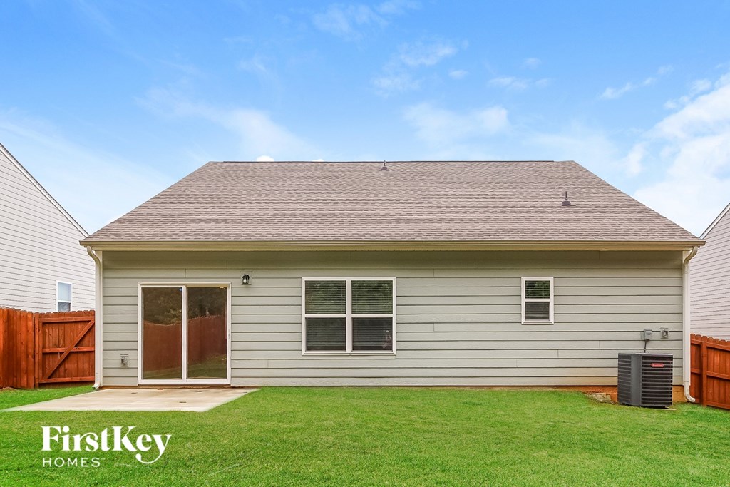 A house with a grey siding and a brown roof with a small window on the right side.
