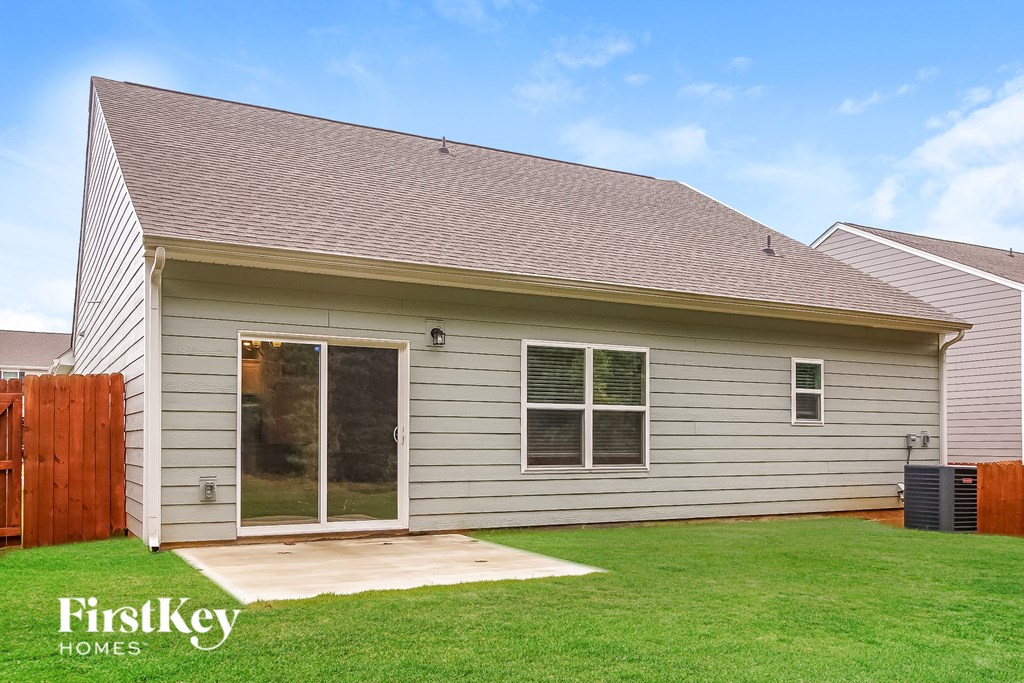 A house with a grey siding and a brown roof with a glass door and a window.