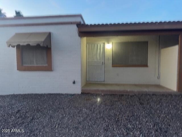 A small white house with a brown roof and a brown door.