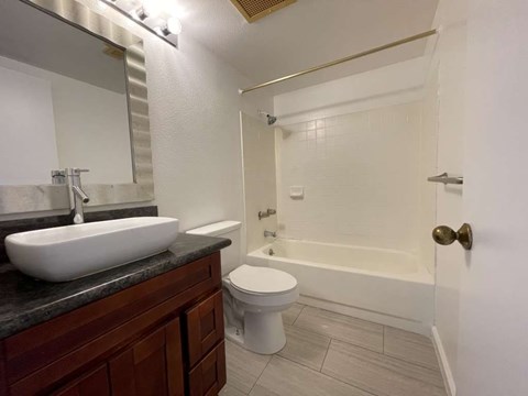 A bathroom with a sink, toilet, and bathtub.