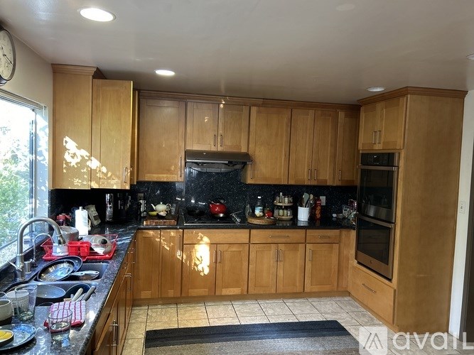 A kitchen with wooden cabinets and black countertops.