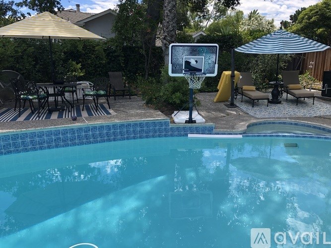 A pool with a basketball hoop in the middle of it.