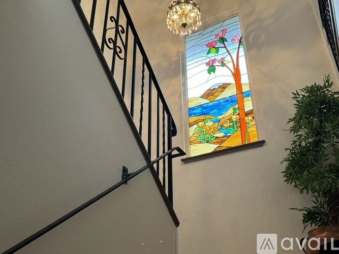 A stained glass window with a tree and flowers is on the wall.