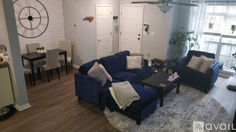 A living room with a dark blue sofa and a wooden floor.