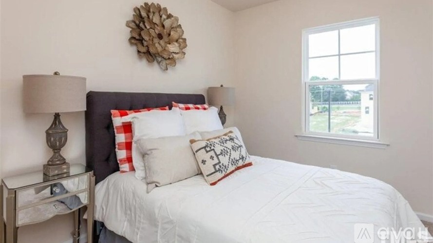 A bedroom with a bed, nightstand, and window.