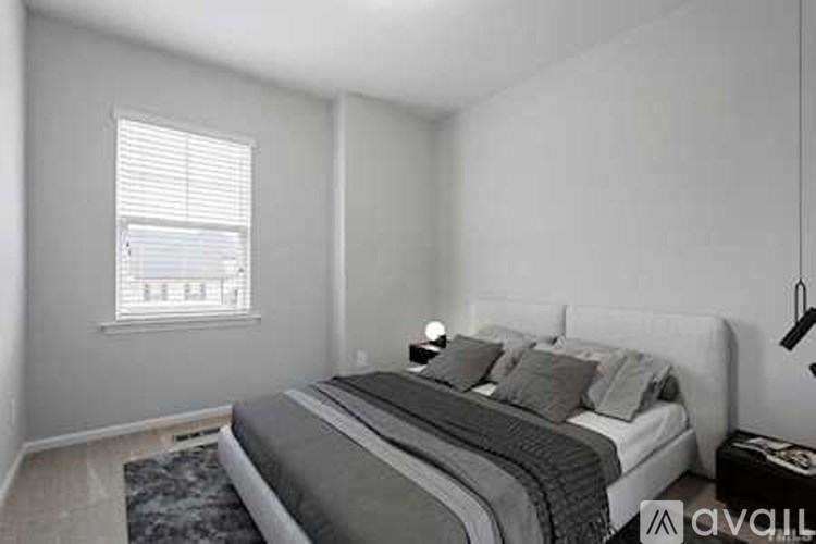 A bedroom with a bed, nightstand, and window.