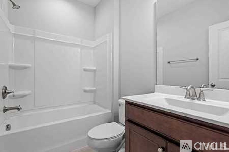 A white bathroom with a toilet, sink, and bathtub.