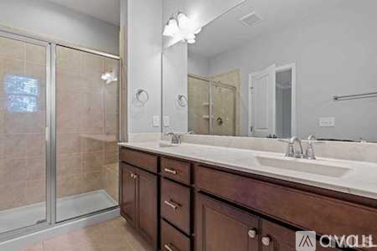 A bathroom with a sink, mirror, and shower.