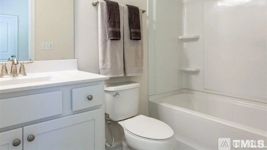 A white toilet sits in a bathroom next to a white sink.