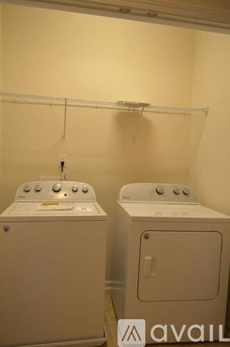 Two white front loading washing machines in a laundry room.